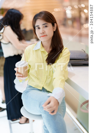 young woman drinking coffee, female hand holding and enjoying a cup of tea at cafe shop 104154887