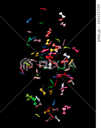 Bows flying in air. Many small ribbon in red, blue, pink, yellow throw explosion. Small Bow floating abstract black background isolated, high speed shutter freeze action 104155720