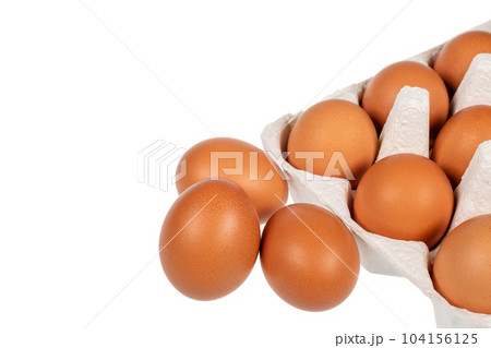 Eggs in an egg carton and eggs placed next to it on a white background Eggs in an egg carton and eggs placed next to it on a white background 104156125