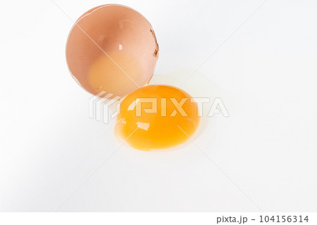 Yolk in an eggshell on a white background. Yolk in an eggshell on a white background. 104156314