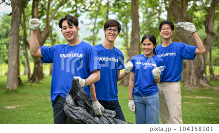 A group of happy Asian volunteers with garbage bags are standing in the public park A group of happy Asian volunteers with garbage bags are standing in the public park 104158101