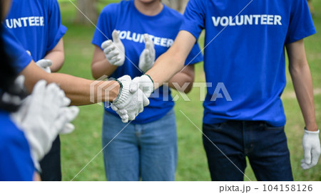 Close-up image of a male volunteer shakes hands with his team after finishing volunteer work 104158126