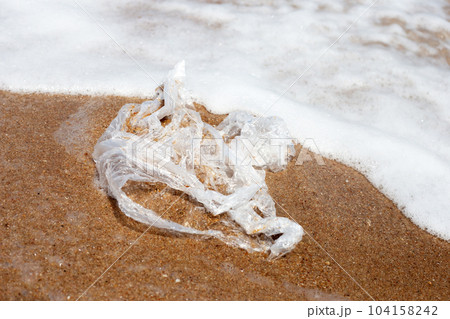 Plastic bag pollution on the beach 104158242