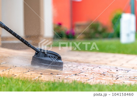 detail of machine cleaning concrete pavement in front of the house with a brush, copy space detail of machine cleaning concrete pavement in front of the house with a brush, copy space 104158460