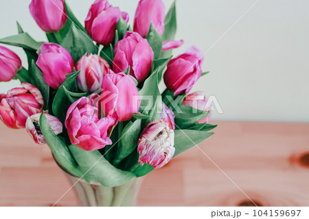 Close up tulips bouquet in a vase over wooden background 8 March greeting 104159697