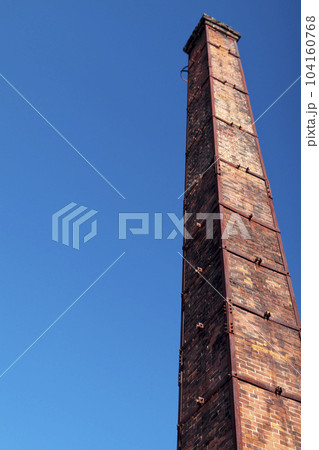街中にレンガ造りの煙突が青空に向かって立っている 街中にレンガ造りの煙突が青空に向かって立っている 104160768