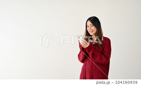 A pretty Asian woman using her smartphone. isolated on white background A pretty Asian woman using her smartphone. isolated on white background 104160939