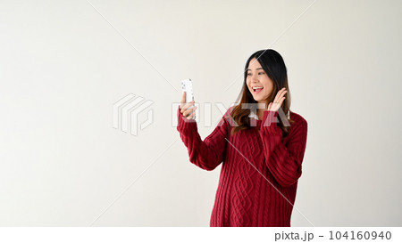 A cheerful Asian woman enjoys talking on a video call with her friend. isolated on white background A cheerful Asian woman enjoys talking on a video call with her friend. isolated on white background 104160940