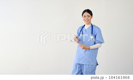 A female doctor or medical worker in scrubs holding a medical clipboard 104161908