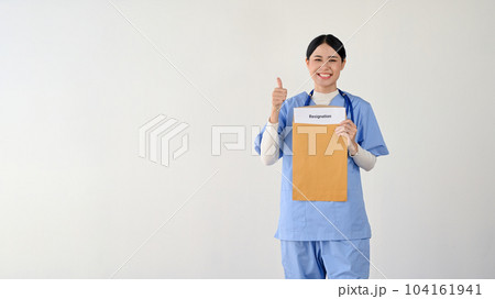 A cheerful Asian female doctor holding a resignation letter and showing her thumb up 104161941