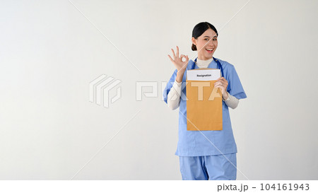 A cheerful Asian female doctor showing the Okay hand sign, happy to resign or quit the job. A cheerful Asian female doctor showing the Okay hand sign, happy to resign or quit the job. 104161943