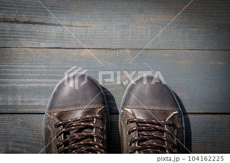 Concept of success and goals. Shoes on a wooden texture background Concept of success and goals. Shoes on a wooden texture background 104162225