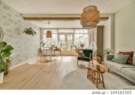 a living room with couches, chairs and plants on the wall in front of the door to the dining area 104162305