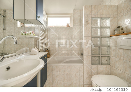 a small bathroom with a toilet, sink and bathtub in the corner next to it is a window that looks out onto the a small bathroom with a toilet, sink and bathtub in the corner next to it is a window that looks out onto the 104162330