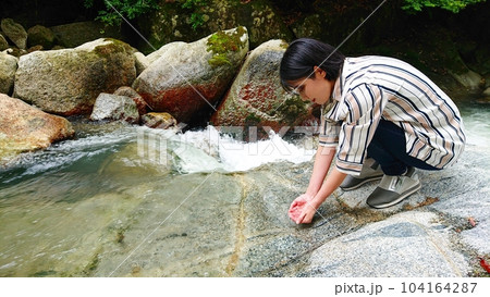 川の水に触れる 104164287