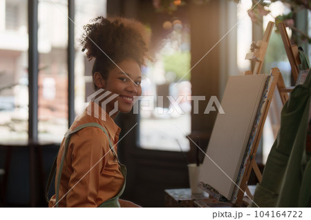 Beautiful american african artist woman painting in art studio at the university classroom Beautiful american african artist woman painting in art studio at the university classroom 104164722