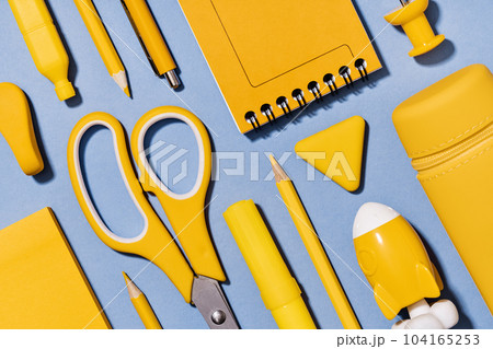 Assorted office and school yellow stationery on lilac blue. Full frame for back to school or education craft office work concept. Bright Yellow rocket. Achievement and success. Top view Assorted office and school yellow stationery on lilac blue. Full frame for back to school or education craft office work concept. Bright Yellow rocket. Achievement and success. Top view 104165253