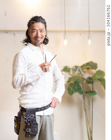 シザーを手に持ち、ポーズをとるベテランのヘアスタイリスト シザーを手に持ち、ポーズをとるベテランのヘアスタイリスト 104166762