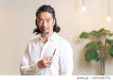 シザーを手に持ち、ポーズをとるベテランのヘアスタイリスト シザーを手に持ち、ポーズをとるベテランのヘアスタイリスト 104166770