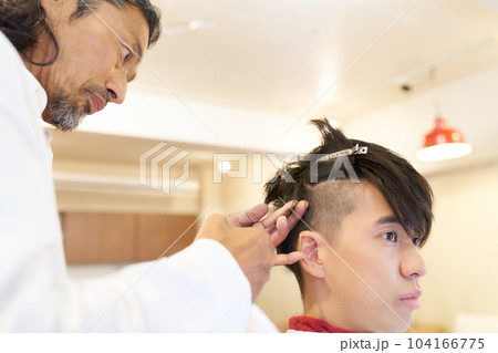 男性の髪の毛をカットするヘアスタイリストの手元 104166775