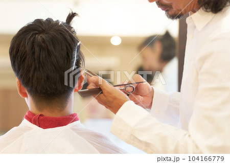 男性の髪の毛をカットするヘアスタイリストの手元 104166779