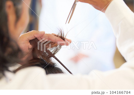 髪の毛をカットするヘアスタイリストの手元 104166784