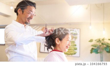 ヘアサロンにて施術中のヘアスタイリストと女性客 ヘアサロンにて施術中のヘアスタイリストと女性客 104166793