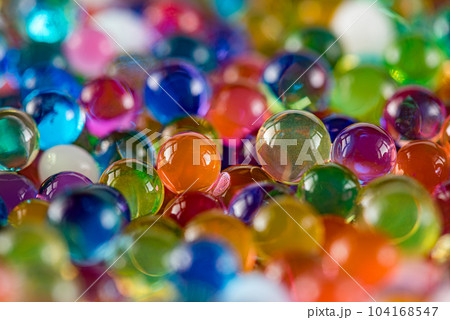 Water beads close-up, abstract background. Texture of Hydrogel balls or many colorful orbeez for wallpaper. Water beads close-up, abstract background. Texture of Hydrogel balls or many colorful orbeez for wallpaper. 104168547