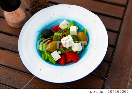 Salad with olives, tomatoes, cucumber and feta cheese - greek vegetable salad. Traditional mediterranean cuisine Salad with olives, tomatoes, cucumber and feta cheese - greek vegetable salad. Traditional mediterranean cuisine 104169063