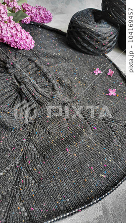 Knitted handmade products. Knitted sweater made of tweed threads. Gray background. Knitted handmade products. Knitted sweater made of tweed threads. Gray background. 104169457