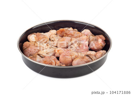 Ready-to-bake chicken drumsticks in a round metal mold over a white background. Ready-to-bake chicken drumsticks in a round metal mold over a white background. 104171886