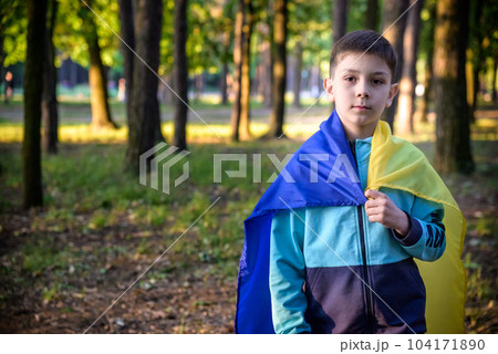 Worried teenager patriot wear blue yellow Ukrainian flag on his Worried teenager patriot wear blue yellow Ukrainian flag on his 104171890