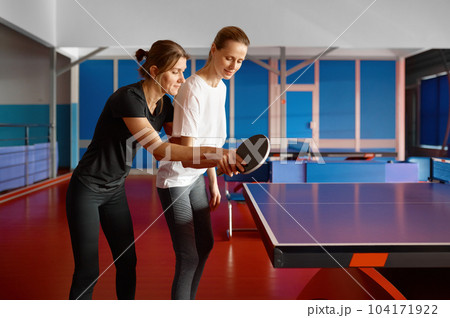 Adult woman instructor teaching female student play table tennis 104171922