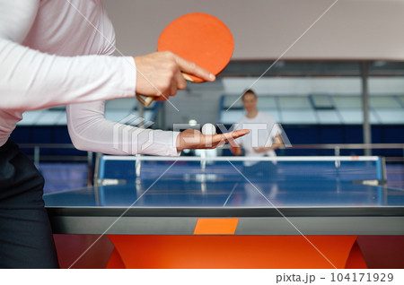 Man and woman playing table tennis, focus on sportsman player serving Man and woman playing table tennis, focus on sportsman player serving 104171929
