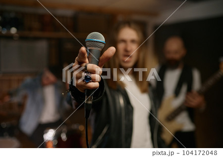 Man rocker wearing style with black jacket and white t-shirt with microphone Man rocker wearing style with black jacket and white t-shirt with microphone 104172048