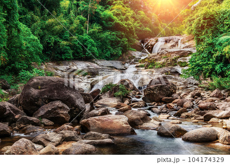 Water fall with sunlight and sunray and dark filter style 104174329