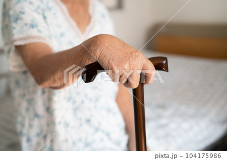 Asian elderly disability woman holding waling stick, wood cane, round handle, walking aid for help to walk. Asian elderly disability woman holding waling stick, wood cane, round handle, walking aid for help to walk. 104175986