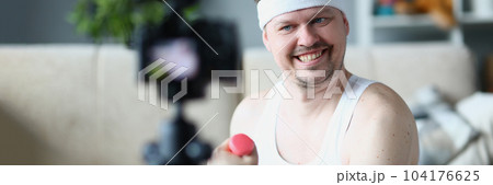 Smiling happy sports blogger blogging about exercises with dumbbells Smiling happy sports blogger blogging about exercises with dumbbells 104176625