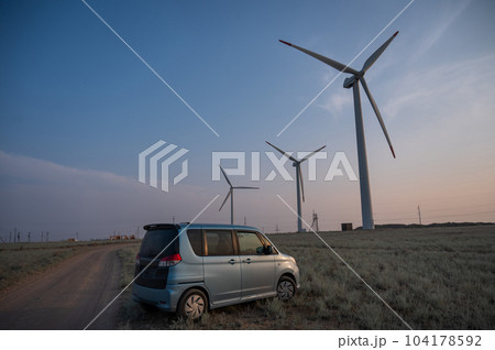 Blue car at windmills at sunset. Alternative energy source.  104178592