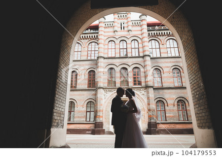 Gorgeous wedding couple walking in the old city of Lviv 104179553