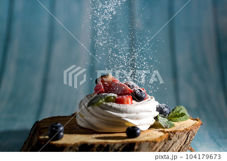Powdered sugar decorates Pavlova's dessert 104179673