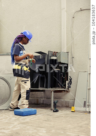 Specialist worker commissioned by home owner for air conditioner annual cleaning and maintenance, removing built up layer of dirt and dust from internal parts to prevent compressor damage Specialist worker commissioned by home owner for air conditioner annual cleaning and maintenance, removing built up layer of dirt and dust from internal parts to prevent compressor damage 104183637