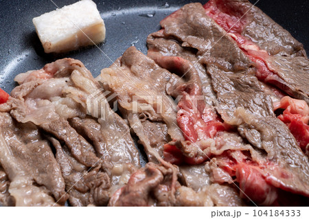 牛肉(ウデ薄切り)をフライパンで焼く調理シーン。 104184333