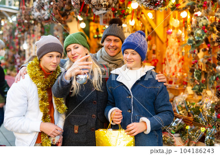 Family of four choosing decorations at Christmas fair Family of four choosing decorations at Christmas fair 104186243