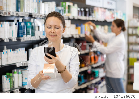 Adult woman looking for cosmetic product from photo on internet 104186670