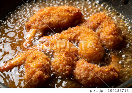 残った揚げ物(エビフライ)リメイク調理シーン。卵とじするためだし汁の入ったフライパンで煮る。 残った揚げ物(エビフライ)リメイク調理シーン。卵とじするためだし汁の入ったフライパンで煮る。 104188718