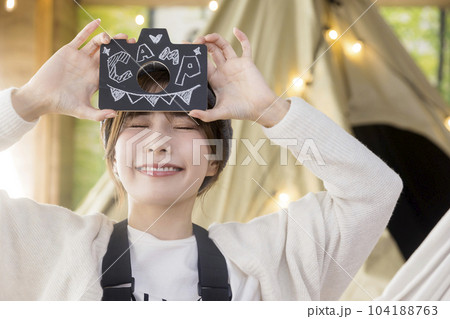 ハンモックに座って文字を見せる若い女性　　家キャン おうちキャンプ　キャンプイメージ 104188763