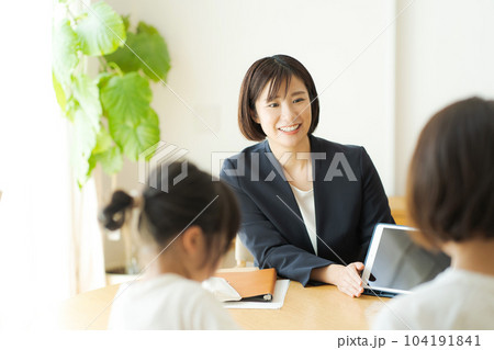親子と話すスーツの女性の写真 104191841