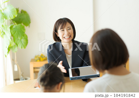 親子と話すスーツの女性の写真 104191842