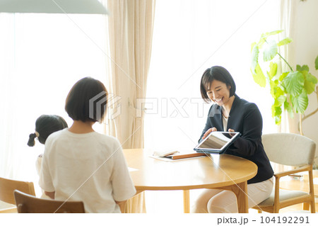 親子と話すスーツの女性の写真 親子と話すスーツの女性の写真 104192291